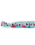 Dive into summer with our adorable pink flamingo hair tie on a blue ocean background.