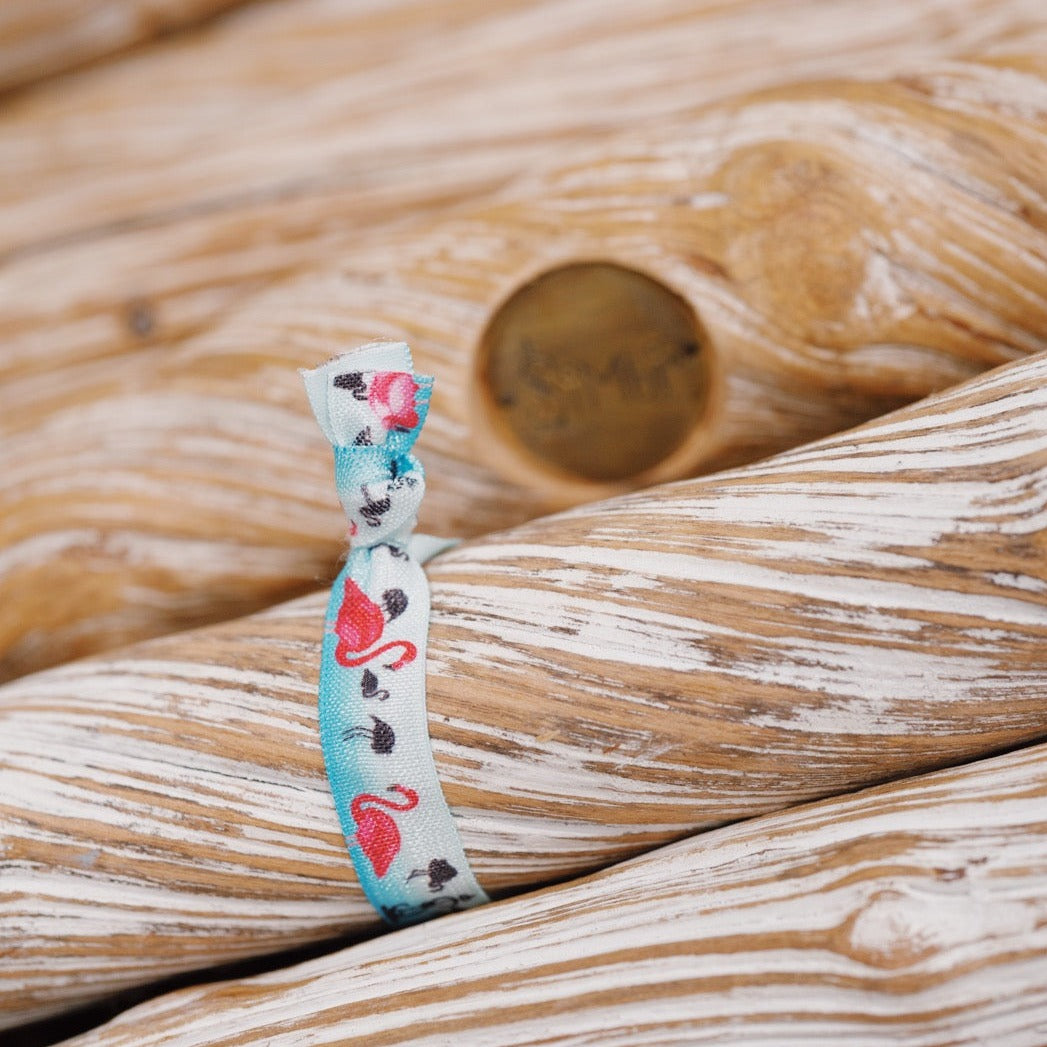  pink flamingo hair tie on a blue ocean background.