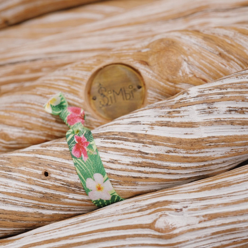 Stylish hibiscus hair tie with green foliage.