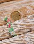 Stylish hibiscus hair tie with green foliage.